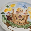 Ceramiczny talerz dekoracyjny z dzieckiem w kołysce – ręcznie malowany, Ø 17 cm