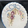 Dekoracyjny talerz ceramiczny z owocowym ornamentem i kokardą – średnica 22 cm
