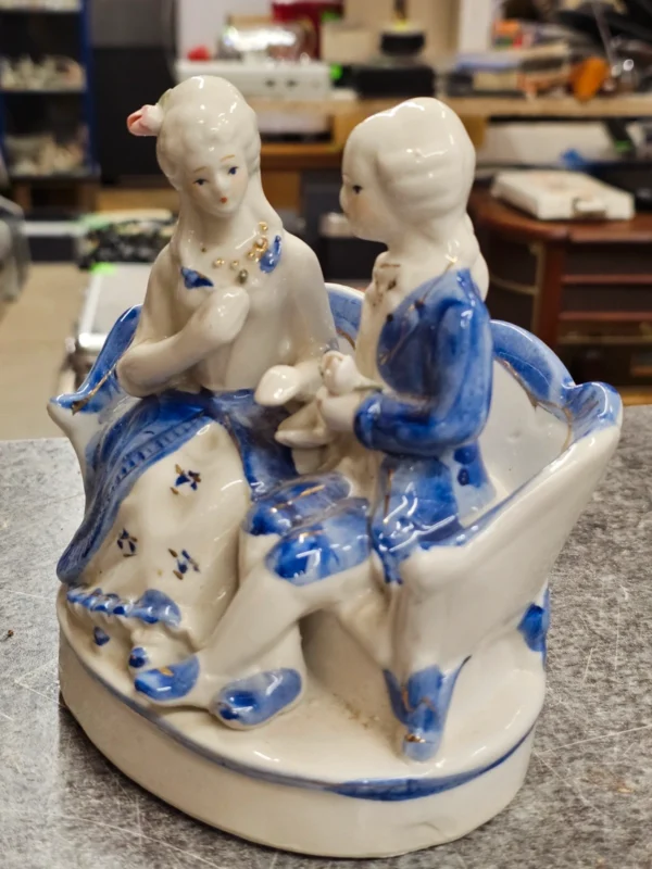 Figurka porcelanowa para na sofie – niebiesko-biała