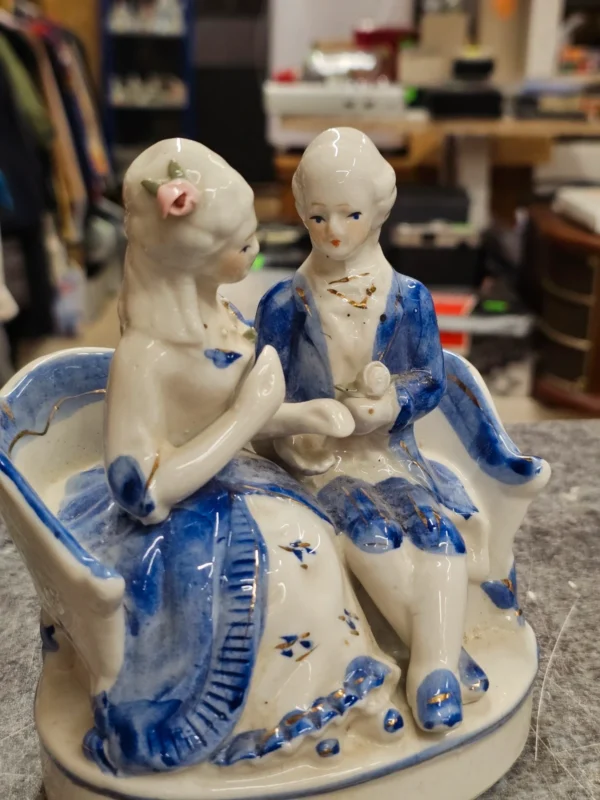 Figurka porcelanowa para na sofie – niebiesko-biała