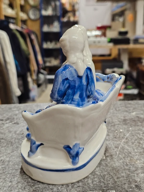 Figurka porcelanowa para na sofie – niebiesko-biała