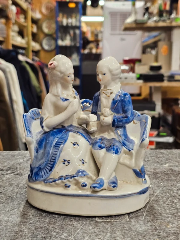 Figurka porcelanowa para na sofie – niebiesko-biała
