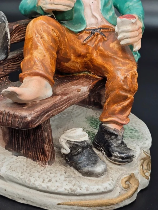 Ręcznie malowana figurka – starszy mężczyzna na ławce z butelką – ceramika, wys. 20 cm