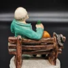Ręcznie malowana figurka – starszy mężczyzna na ławce z butelką – ceramika, wys. 20 cm