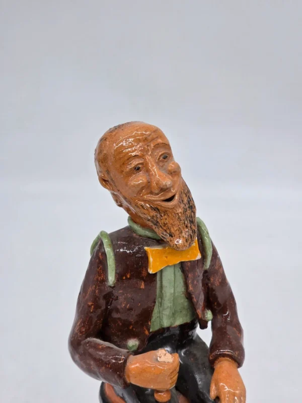 Figurka ceramiczna starszy pan siedzący na beczce wysokość 22 cm