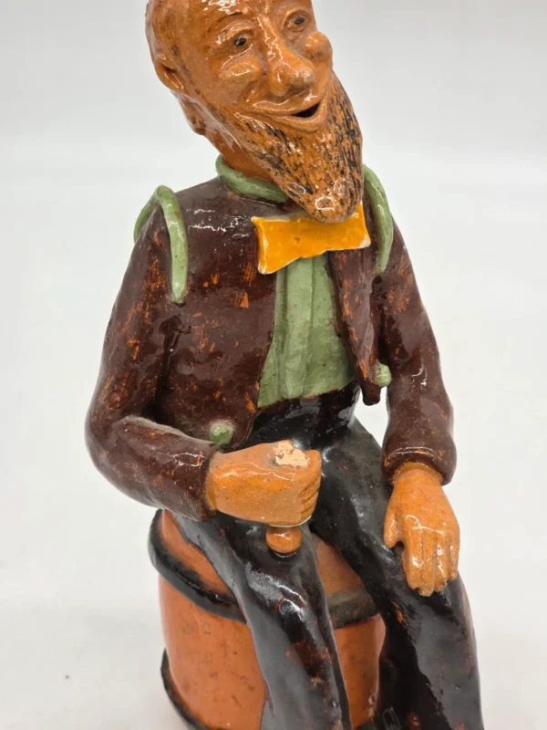 Figurka ceramiczna starszy pan siedzący na beczce wysokość 22 cm