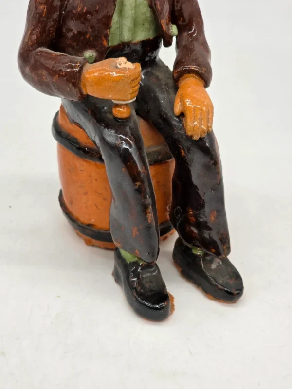 Figurka ceramiczna starszy pan siedzący na beczce wysokość 22 cm