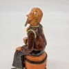 Figurka ceramiczna starszy pan siedzący na beczce wysokość 22 cm