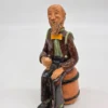 Figurka ceramiczna starszy pan siedzący na beczce wysokość 22 cm