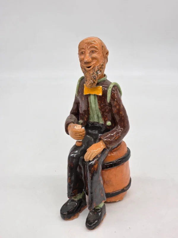 Figurka ceramiczna starszy pan siedzący na beczce wysokość 22 cm