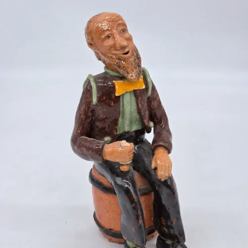 Figurka ceramiczna starszy pan siedzący na beczce wysokość 22 cm