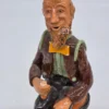 Figurka ceramiczna starszy pan siedzący na beczce wysokość 22 cm