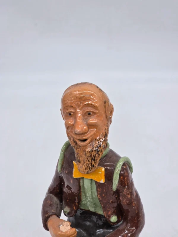 Figurka ceramiczna starszy pan siedzący na beczce wysokość 22 cm
