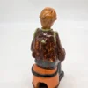 Figurka ceramiczna starszy pan siedzący na beczce wysokość 22 cm
